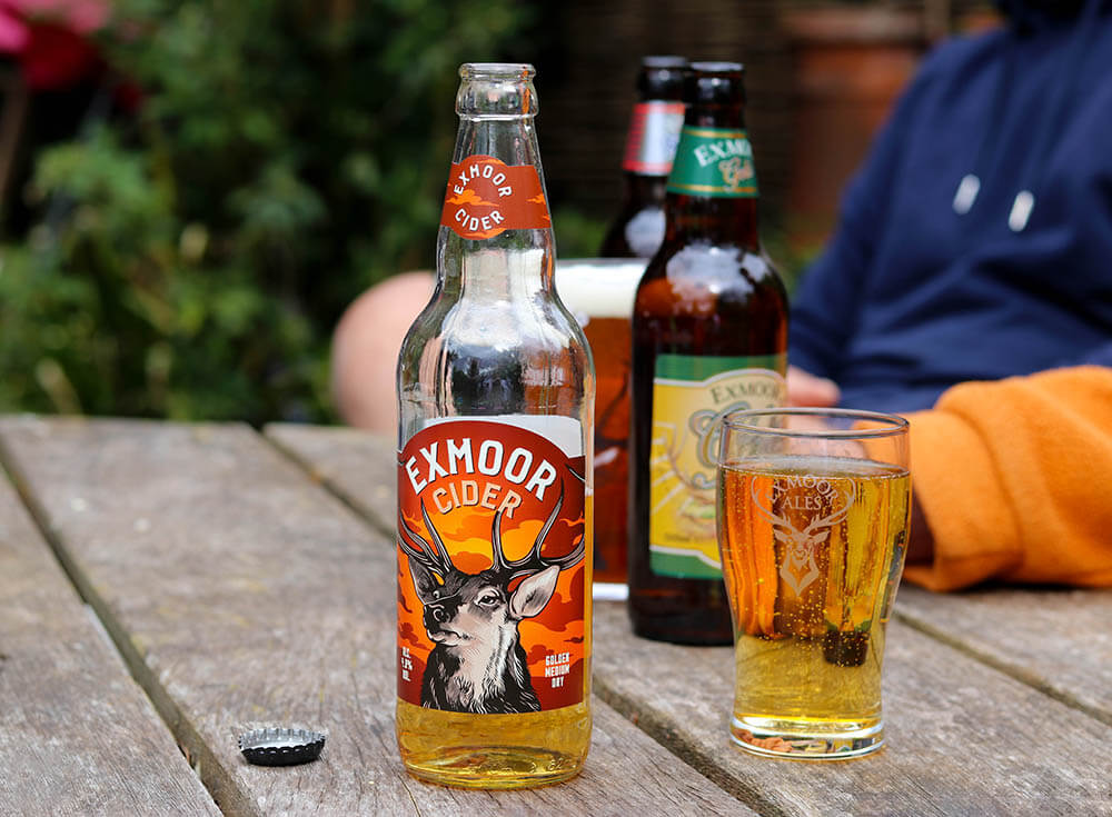 Exmoor Cider bottle and full glass of cider on a garden table