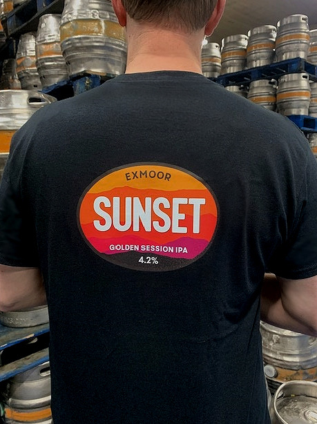Back of the Sunset IPA T-shirt being worn by employee standing in a brewery.